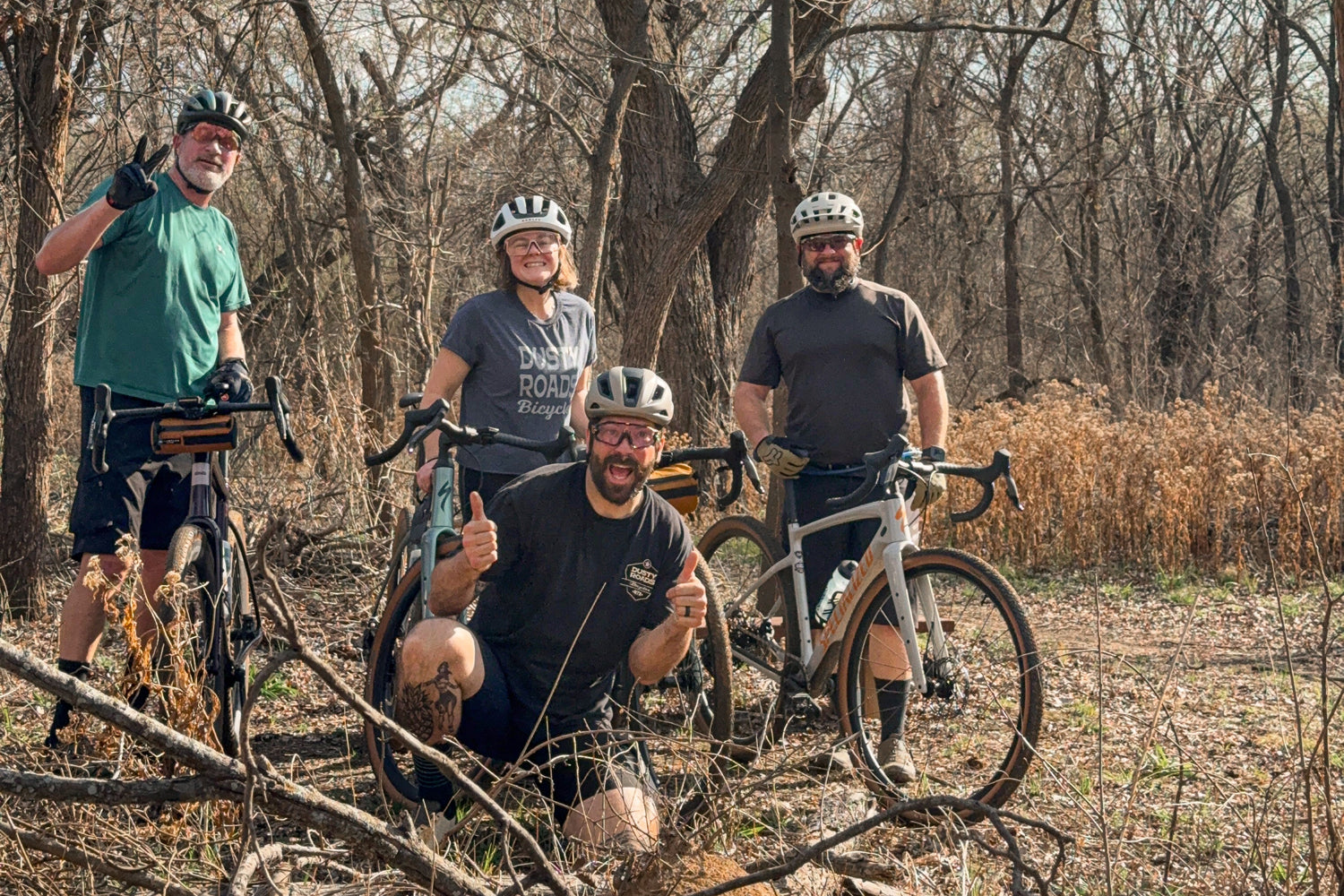 Four cyclists with their bicycles in a forest setting