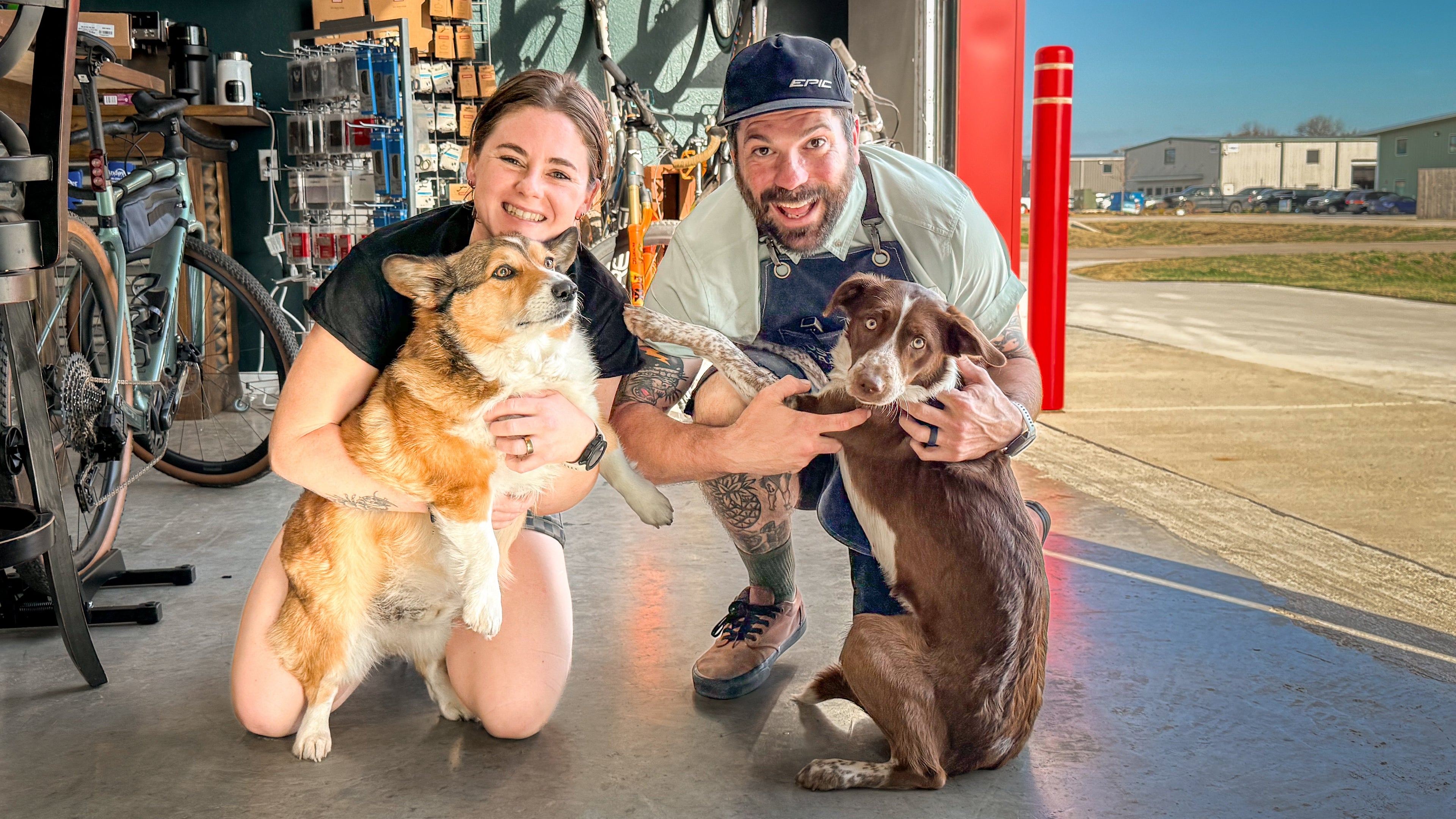 Two people with two dogs in a workshop setting